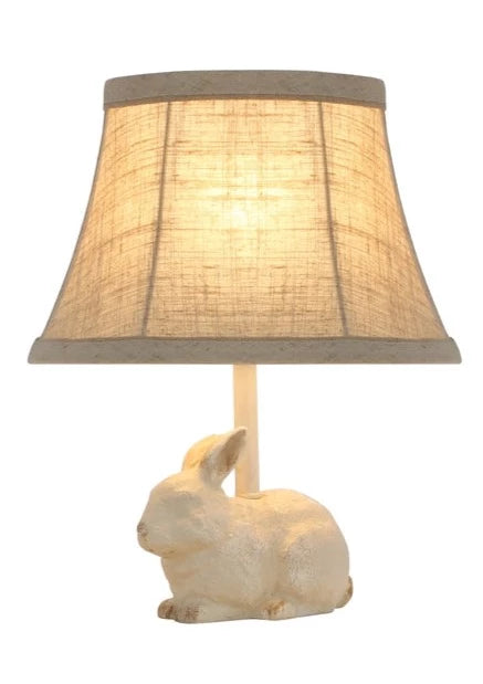 This little bunny lamp is perfect for a powder room, bedroom, or bookcase. Use it as a night light or accent light. The natural cotton/linen shade features a tan contrasting trim that accentuates the light brown accent on the bunny's paws, ears, and tail.  25-watt bulb not included.  12