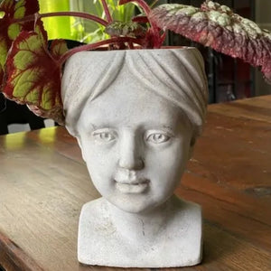 We just love these cement planters! This one is of a girl with an open top opening that will hold plant types, including succulents. Use indoors or outside. Natural color changes will occur in the concrete, including fungus growth, if used outside.  The finish will vary.  5" W x 5.5" D x 7.7" H