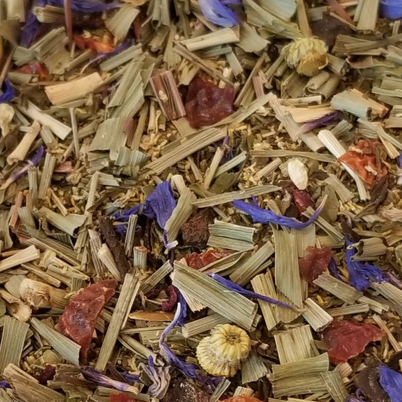 Lullaby tea: herbs & fruit: lemongrass, peppermint, camomile, rosehip, spearmint, valerian root, hibiscus, cornflower petals, natural flavors that are organic compliant. The loose herbs and fruit are on a white plate with a blue onion pattern design.