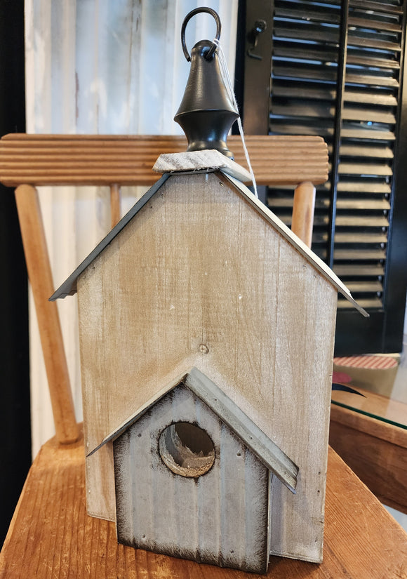 This fun birdhouse has a distressed finish with metal finishes on the front and a metal roof up top.  On top o the roof, there is a black wooden finial with a ring to easily hang your birdhouse if you wish!  The side of it has an opening through to the other side. 6