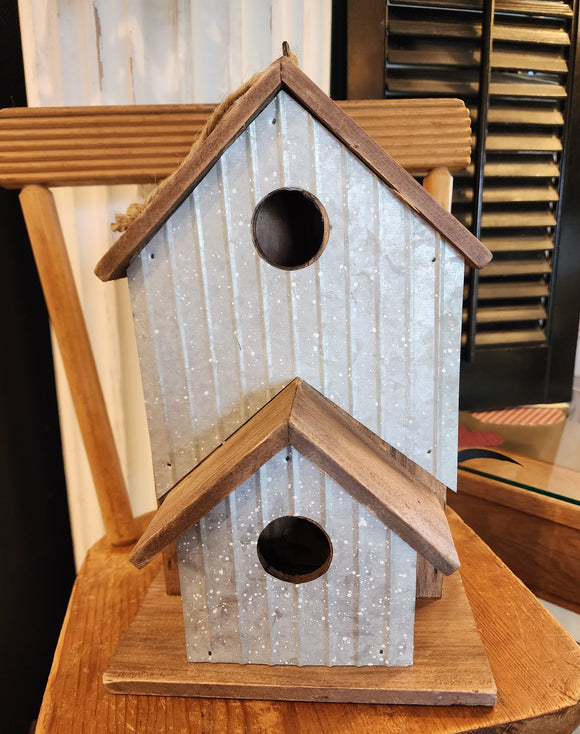 This birdhouse will look cute anywhere you put it inside or outside of your home!  There is a large birdhouse with a smaller one in front of it.  Both fronts have a distressed white splattered finish on the galvanized metal.  There is a rope attached to the black hook on the top of the largest birdhouse to easily hang it if you wish! 6.75