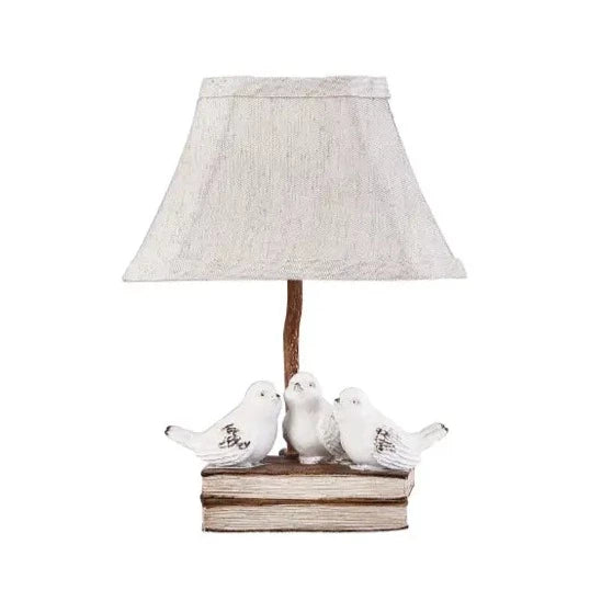 This adorable lamp with three distressed white birds sitting on top of two books will be the brightest spot in your house!  25-watt bulb required  Dimensions with shade: 8.5″w x 5.3″d x 12″h