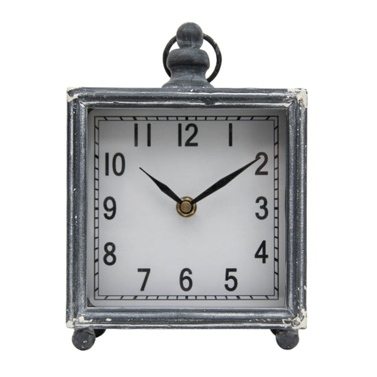 You'll love how this square clock will fit perfectly into your living room, bedroom, or even bathroom!  The charcoal grey metal washed finish has white distressing on the corners making it a great neutral piece in your home. It has a glass face and small metal ball feet and a ring accent on the top.  Ticking mechanism requires an AA battery not included.   6 x 3 x 7.5