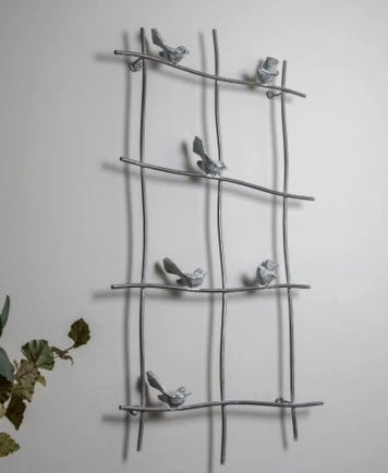 This sweet bird wall art mimics a windowpane and is a unique statement piece to give your wall dimension. The crisscross frame sits out from the wall and six small cast iron birds are perched on the branches throughout. The sleek charcoal finish has a bit of shine paired with whitewashing to enhance the detail of the cast birds.  17