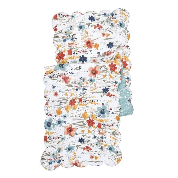 This happy watercolor wildflower floral table runner is a conversation piece in and of itself. Its watercolor wildflowers in vivid terracotta, yellows, aqua, and blue create an eye-catching display. The pattern reverses to an abstract aqua and white floral pattern for a more subdued statement. It will easily brighten any tablescape. Finished with a scalloped edge, this tabletop collection is crafted of 100% cotton and hand-guided machine quilting.