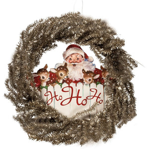 A festive, vintage-inspired tinsel wreath with a wooden accent featuring Santa and three of his reindeer with the words "Ho Ho Ho" on the fence below.   Dimensions: 24" dia Wood, Paper, Tinsel, Wire, Glitter