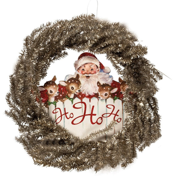 A festive, vintage-inspired tinsel wreath with a wooden accent featuring Santa and three of his reindeer with the words 
