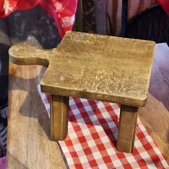 This distressed wooden stool is perfect for setting a plant, small lamp, or cute vignette on!  If you need to give something some height to your decor, this little stool will help you do just that!  Square top.  4.5