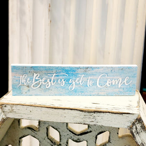 This mini sign has a turquoise blue washed wooden background with the words "the Best is yet to Come" written in a white cursive font.   Wood Depth: 0.4375" Width: 6" Height: 1.5"