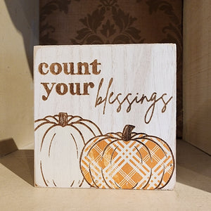 This weathered white wooden block has the cutest orange plaid pumpkin and white pumpkin on it with the words "Count Your Blessings" above. It is freestanding so you can use it anywhere in your fall decor this year!   4″W x 4″H x 1.3″D