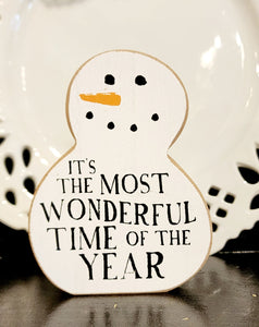 Bring dreams of a white Christmas a little closer to the farmhouse this year with this cute chunky snowman sitter!  White, with raw edges, this wooden snowman has a cute smile, orange carrot nose and "It's the most wonderful time of year" on his belly.   3.5″W x 0.8″D x 4.5″H
