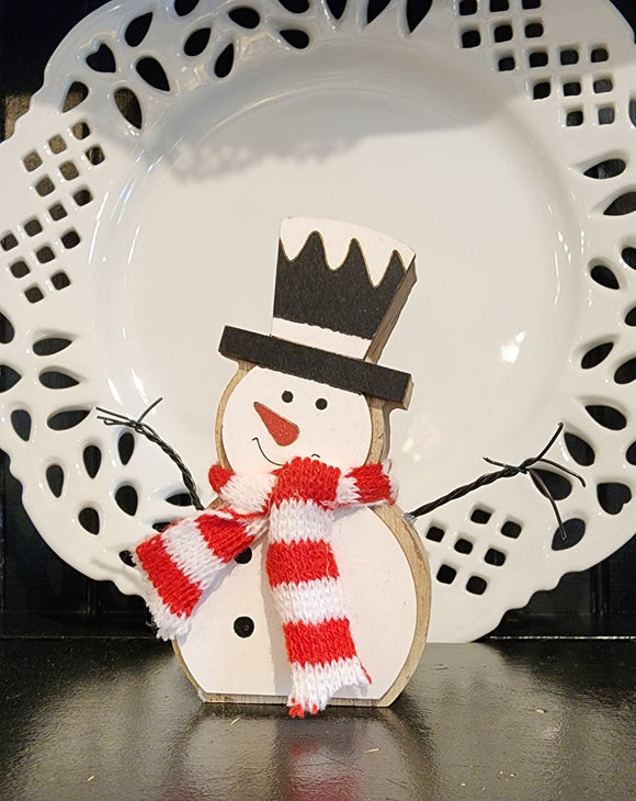 This cute little snowman sitter will be a great addition to your winter decor!  With bendable white, black arms, a red and white striped scarf, and a black top hat, he will make your heart melt!  4.5