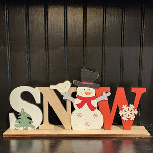 This adorable snowman is the "O" in the word SNOW in this sign. He has a red scarf, red snowflakes, and grey polka dots on his belly. He is holding a white bird in his right hand. The letters in SNOW are all different colors. The "S" is white, the "N" is natural wood, the snowman makes the "O," and the "W" is red.  4.75"H x 10.25"W x 2"D
