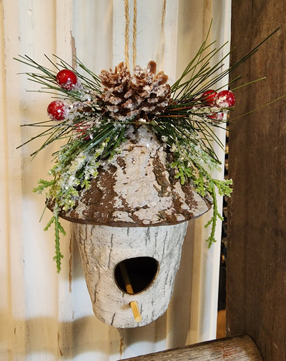The perfect ornament for your favorite bird lover!  This round birch birdhouse has evergreen and berries decorating the top and comes with a twine string to hang.  3