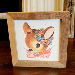 This adorable vintage doe has a pink bow and a vintage Christmas bulb wreath around its ear. It will surely be your favorite little picture to decorate with this holiday season!  It is made from high-quality American hardwood planks with a hand-painted face, printed with UV-cured ink, and framed in a natural walnut frame. Each piece is unique with its own personality, marks, wood grain, and look. Easy to clean with a dry cloth.  Made in the USA  4" x 4" x 1"