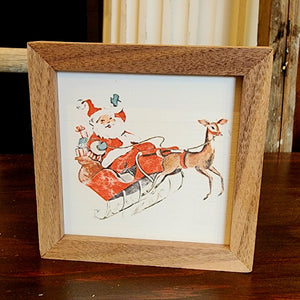 Up, up & away!!! Santa is in his sleigh with one of his reindeer pulling it ~ it is oh-so retro looking, you'll love to decorate with this for the holidays!  It is made from high-quality American hardwood planks with a hand-painted face, printed with UV-cured ink, and framed in a natural walnut frame. Each piece is unique with its own personality, marks, wood grain, and look. Easy to clean with a dry cloth.  Made in the USA  4" x 4" x 1"