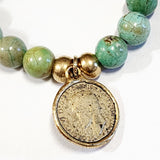 Wear one or stack them high. Our Gemstone Stretch Beaded Bracelets go with anything. Beautiful blue turquoise is threaded on a stretch band and has two gold beads with a gold coin on it.  On one side of the coin is a bird with the date 1938 above and the word "FARTHING" below. On the back side is a man's side profile with letters all around the coin.
