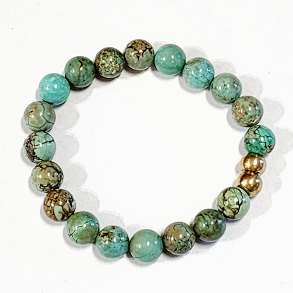 Wear one or stack them high. Our Gemstone Stretch Beaded Bracelets go with anything. Beautiful blue turquoise beads are threaded on a stretch band with two gold beads in the center.
