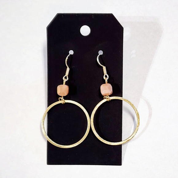 These stylish earrings have a peach bead hanging above the brushed gold circle  Approximately 2.75