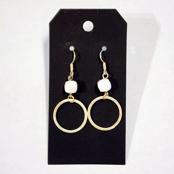 These stylish earrings have a white bead hanging above the brushed gold circle  Approximately 2.25