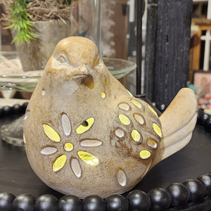 This bird figurine will put a BRIGHT spot in your home! This bird has flower cut-outs on its chest and back with several oval cut-outs on its wings to let the LED light inside out to shed some light on your decor! The bird has a distressed brushed-on brow/tan finish with white highlights. You'll love this so much, you'll want both styles!  6" H x 7" W x 4.5" D  Polyresin, Stone Powder  Requires 3 AAA Batteries