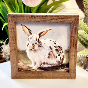 This adorable speckled bunny will look too cute in your decor (don't you just want to take him home with you??!!)   This unique piece is a simple way to bring beauty and charm to any wall or shelf within the home. It is made from high-quality American hardwood planks with a hand-painted face, printed with UV-cured ink, and is framed in a natural walnut frame. 