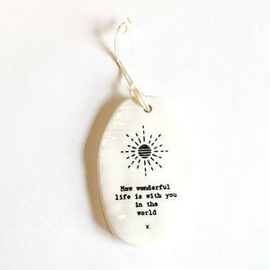 <p><span data-mce-fragment="1">This oval-shaped porcelain ornament is perfect to give to someone to let them know you are thinking of them! A sun is shining on the ornament with the words: "How wonderful life is with you in the world" written below.</span></p> <p><span data-mce-fragment="1">2 1/4" W x 3 1/4" H</span></p>