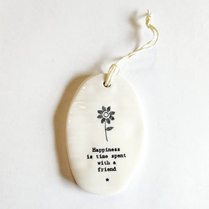 <p><span data-mce-fragment="1">This oval-shaped porcelain ornament is perfect to give to someone to let them know you are thinking of them! A flower is up top with the words "Happiness is time spent with a friend."</span></p> <p><span data-mce-fragment="1">2 1/4" W x 3 1/4" H</span></p>