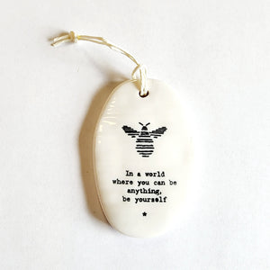 <p><span data-mce-fragment="1">This oval-shaped porcelain ornament has a bee at the top and says "In a world where you can be anything, be yourself" below.&nbsp; It is perfect to give to someone to let them know you are thinking of them!</span></p> <p><span data-mce-fragment="1">2 1/4" W x 3 1/4" H</span></p>