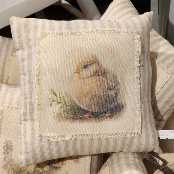 <p>This beautiful neutral pillow will fit in with any spring decor! A sweet little yellow chick sits by some greenery with little white flowers. The image is printed on cream fabric that has been fringed and then attached to a taupe ticking stripe fabric pillow.<br></p> <p>Approximately 8<span data-mce-fragment=