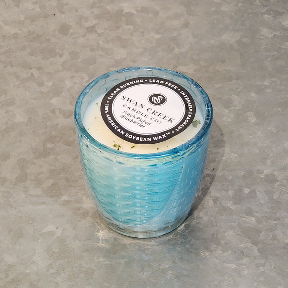 You'll love our newest candle style and size! This fresh-picked blueberry candle has been poured into a pretty basketweave-patterned bright blue glass.