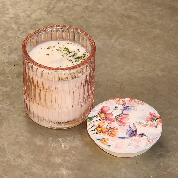 <p><span>You'll love our newest candle style and size! This citrus grove candle has been poured into a pretty basketweave pink glass with a butterfly or hummingbird lid.</span></p> <p><span>Vibrant nuances of tangerine, mandarin, and cassis shine on top. Traces of red currants, guava, and lemon flowers are sweet throughout. Bottom notes of green Ivy and lily are added to vanilla sugar for the finishing touches.</span></p>