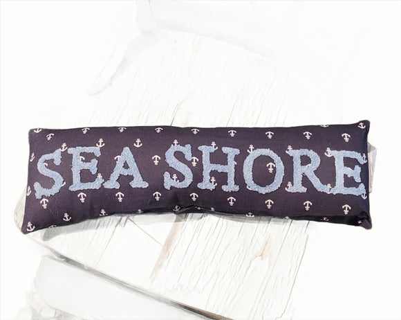 <p>This adorable mini pillow will make you smile every time you SEA it, lol!  There are little white anchors, all of the navy fabric.  Across the front is 