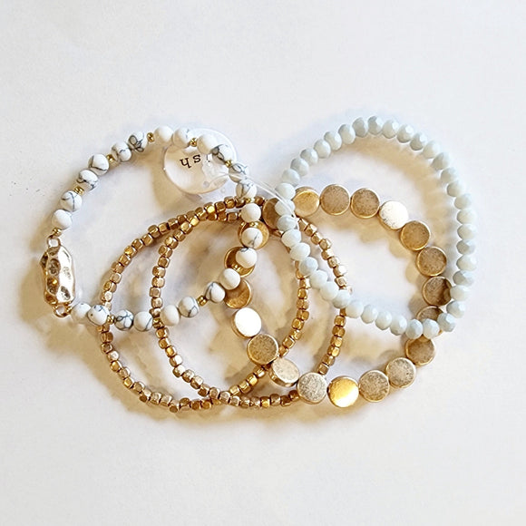 You'll love this five-piece stretch Boho Beaded Bracelet Stack! It consists of a semi-precious metal and howlite glass beaded bracelet, a howlite bracelet with a golden nugget centerpiece, a golden nugget flat beaded bracelet, and two golden nugget bracelets. It's perfect for any season and great to combine with other bracelets for a thicker bracelet stack!  One size fits most.  Metal, glass, and natural howlite stone beads and golden beads.
