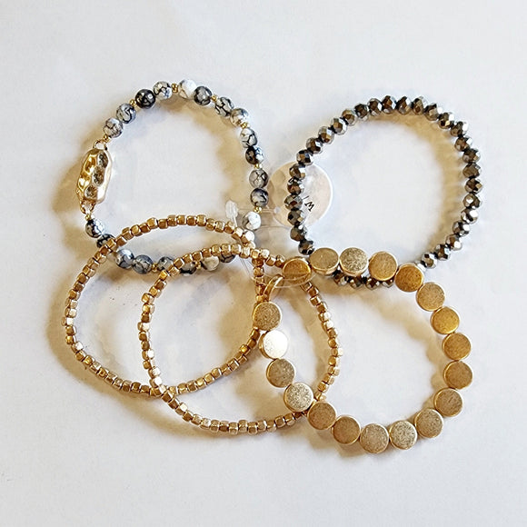 You'll love this five-piece stretch Boho Beaded Bracelet Stack! It consists of a semi-precious metal jasper glass beaded bracelet, a jasper bracelet with a golden nugget centerpiece, a golden nugget flat beaded bracelet, and two golden nugget bracelets. It's perfect for any season and great to combine with other bracelets for a thicker bracelet stack!  One size fits most.  Metal, glass, and natural Jasper stone beads are black, white, as well as gold.