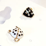 Care for a SPOT of tea?&nbsp; You'll get compliments on these playful black and white teapot and teacup post earrings. They are a whimsical and charming, mismatched pair that celebrates the joy of tea time. They feature a white with black polka dot teapot and a black rhinestone-covered teacup. The intricate detailing and contrasting colors create a playful and eye-catching look. 