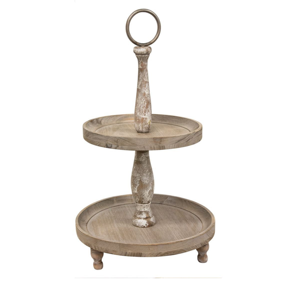 The Weathered Two-Tiered Tray is a farmhouse inspired accessory perfect for kitchens, living rooms, or dining rooms. This wooden two-tiered tray is a freestanding tabletop accessory with three wooden legs, two wooden trays, two distressed wooden beams for support, and a metal circular loop on top. It measures 21” high and 12” in diameter and is perfect for decorating with framed signs, candles, florals, or sitters. The trays can also be used as a functional accent to store knick-knacks, keys, and mail. 
