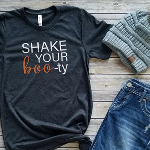 You won't have a ghost of a chance of not getting in the Halloween spirit with this adorable tee!  This grey t-shirt has the words "Shake Your Boo-ty" on it in white and orange in mixed fonts!  Printed direct-to-fabric printing for a soft design that won't crack or peel. The shirts are soft Bella and Canvas unisex fashion-fit tees that fit like a well-loved favorite, featuring a crew neck and short sleeves.  100% Airlume combed and ring-spun cotton.  Made in the United States