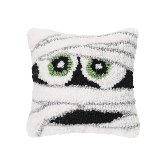 Everyone needs this Mummy pillow for Halloween! With its eyes peeking out of its bandages, it is the most adorable thing that you've seen!  We love its size, it brings fun to your pillow party and will mix nicely with the ones you already have! It will be sure to be a graveyard smash!   8″ x 8″ x 3″  Acrylic front, Cotton canvas backing, Polyester filling