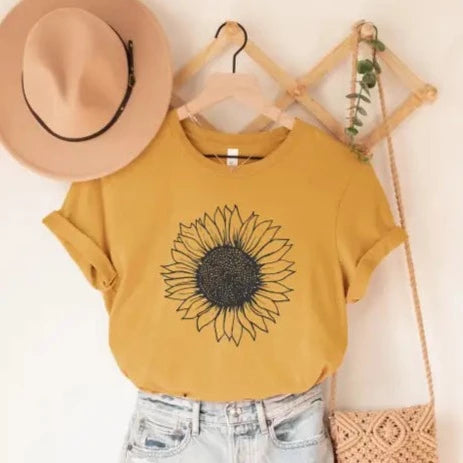 Everyone knows that sunflowers are the HAPPIEST flowers, so be the one that brightens up the room in our Sunflower tee! It is a beautiful mustard color with a gorgeous black outlined sunflower in the center.   These T-shirts are so soft & comfy that you will love wearing them everywhere. The styling possibilities are endless. Roll up the sleeves, tie a side knot, front tuck, or wear it while lounging around the house.