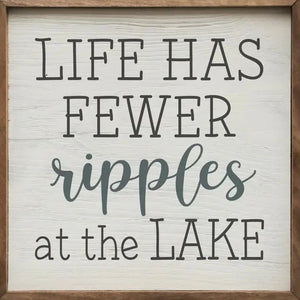 We love this sign! It has the words "Life Has Fewer Ripples At The Lake" in cursive & block font on top of a whitewashed wood background.  It is made from high-quality American hardwood planks with a hand-painted face, printed with UV-cured ink, and framed in a natural walnut frame. Each piece is unique with its own personality, marks, wood grain, and look. Easy to clean with a dry cloth.  Made in the USA  4" x 4" x 1"
