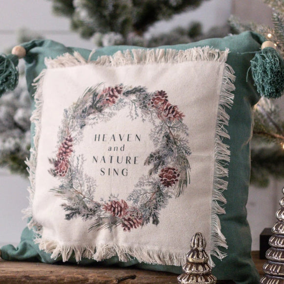 This gorgeous pine green pillow will be a beautiful addition to your holiday decor this year! On top of the green is a frayed cream square that has been stitched onto the pillow.  On it, is a pinecone wreath, and inside it says 