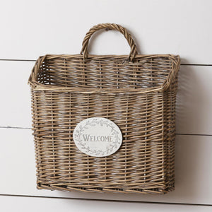 <p>This willow basket has a distressed white metal "welcome" sign on the front. It has a willow handle at the top to easily hang it. You can put it in your entryway, on your front door, or hanging on your covered porch and tuck some artificial or dried flowers in it for the seasons!</p> <p><span>13 H x 12 W x 5 D</span></p> <p><span>Willow (basket), metal (welcome sign)</span></p>