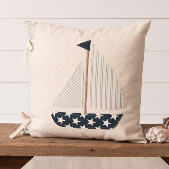 <p>Set sail this summer with our sailboat pillow! A cream slipcover ties over a light blue and cream-striped ticking pillow. On the cream slipcover is a sailboat made out of two different cream and light blue striped fabrics for the sail, a navy fabric with cream stars for the boat, and a twine rope for the staff with a navy flag on top.  It's the cutest pillow to add to your coastal look for your home or porch this year!</p> <p><span>18