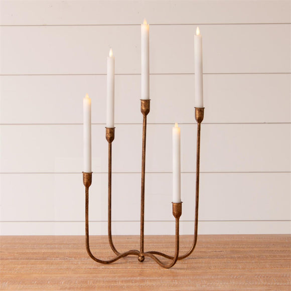 This uniquely designed brass candelabra is sure to be a conversation starter on your table! The five holders, each at a different height, create a visually appealing arrangement for your candles. You can easily enhance the base with seasonal greenery or floral accents.


Brass
17.5 H x 10 W x 7.5 D

Candles not included