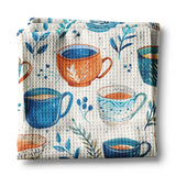 These towels are perfect home and kitchen decor, and also makes a great hostess gift for your next tea party! Blue and orange teacups, teapots and botanical leaves are scattered all over this beautiful white towel.

Measures approximately 16”x 24”

Made of 80% Polyester and 20% Polyamide.

Design is permanently printed - Single side across whole towel

It is called a waffle weave because the towel has raised looped edges on the surface of the towel in the shape like that on a delicious Belgian Waffle. These