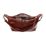 The Danna crossbody is masterfully crafted in our gorgeous new tumbled gloss vegan spicy red leather to give your look a polished yet casual vibe. Fitted with a top zip closure accented by our signature logo zip pull and two removable and interchangeable shoulder straps; a short shoulder strap to wear snug to the body or a long adjustable, removable crossbody shoulder strap to wear as a crossbody, this slouchy hobo design is perfect for your everyday style.


Dimensions: 9.5 in. H X 10.5 in. W X 3.5 in. D
T