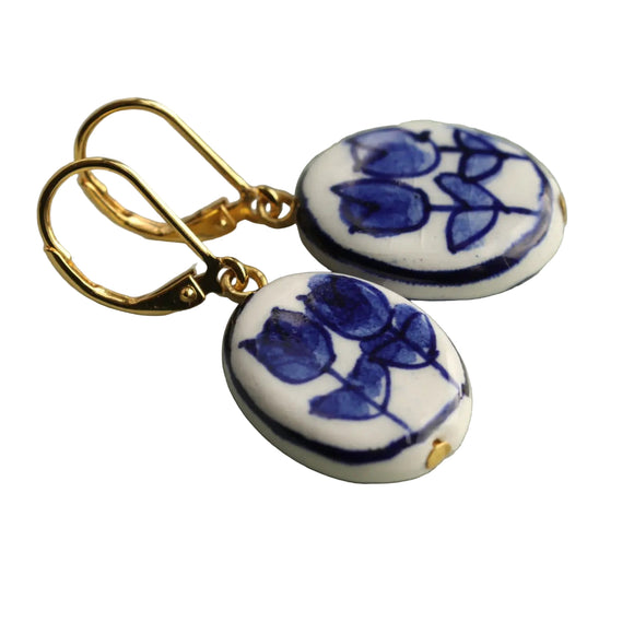 These beautifully painted tulip earrings feature a rich Delft blue on white porcelain. 

The earrings measure just over an inch in length and have solid brass earwires.