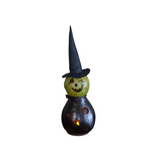 You KNOW you have to have this darling witch this year! Our Fiona witch is hand-crafted from hard shell gourds. She is hand-dyed green and black. expert crafters hand-cut her face and the star and moon design on her belly. She comes with an electric light that shines a warm subtle glow through her crafted design. Her black witch hat is handmade and adorned with fall-colored berries. She has a handmade black clay nose, and black raffia is tied around her neck.

Warning: Gourds are flammable. Do not use candl