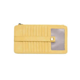 This slim and sleek wallet has nine credit card pockets, each with a snap tab for security and brass-plated hardware. It also features an ID window, a zippered change pocket, and a zippered billfold pocket in sunshine yellow vegan leather.


DIMENSIONS: 3.75 IN. H X 7.25 IN. W X .25 IN. D&nbsp;


100% Vegan leather (polyurethane)